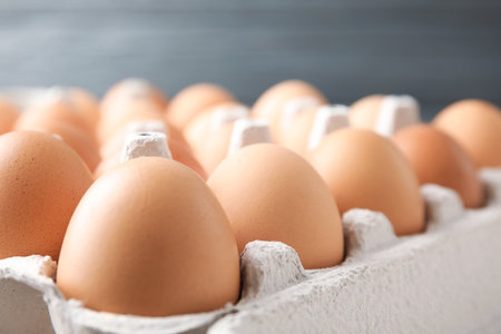 Raw chicken eggs in cardboard, closeup view