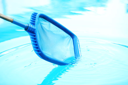 Cleaning outdoor pool with scoop net, closeupの写真素材