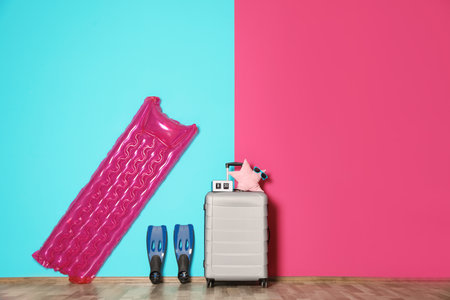 Large suitcase for travel and beach items with space for text near color wall