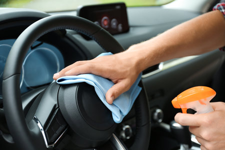 Man washing car salon with rag, closeup