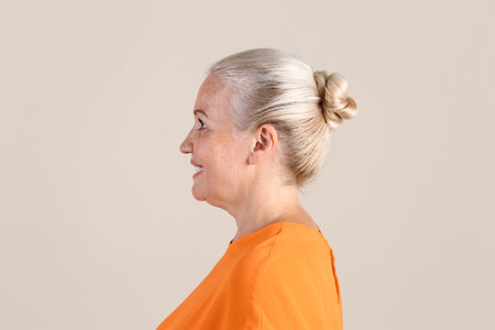 Mature woman on light background. Hearing problemの写真素材