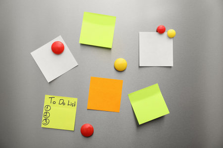 Paper sheets and magnets on refrigerator doorの写真素材