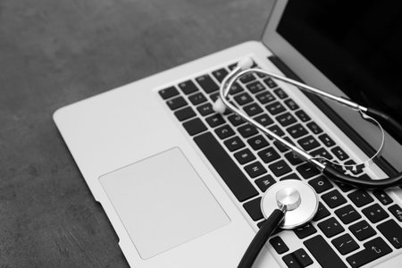 Modern laptop and stethoscope on table. technical support concept