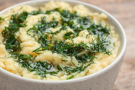 Bowl with tasty mashed potato on table, closeup