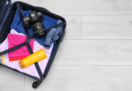 Packed suitcase on wooden background with space for text, top viewの写真素材