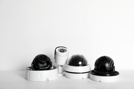 Modern CCTV cameras on table against light background. home alarm system
