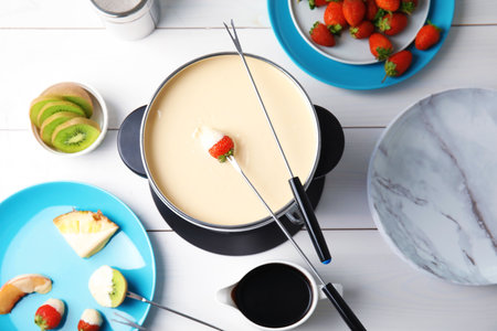 Flat lay composition with chocolate fondue in pot and fruits on wooden backgroundの写真素材