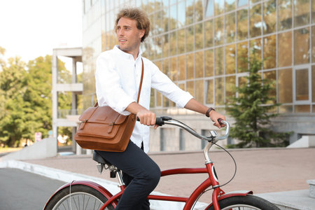 Attractive man riding bike on city street