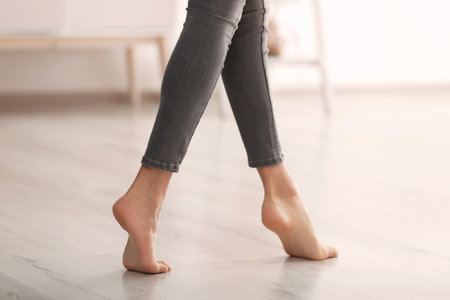 Young woman walking barefoot at home, closeup. heating conceptの写真素材