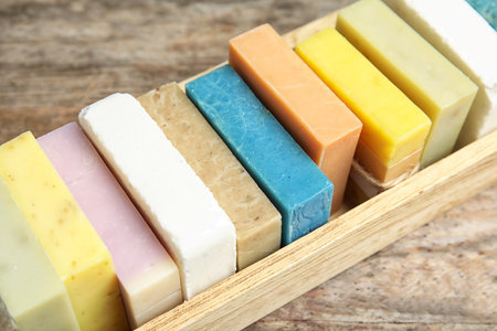 Many different handmade soap bars in wooden box on table, closeupの写真素材