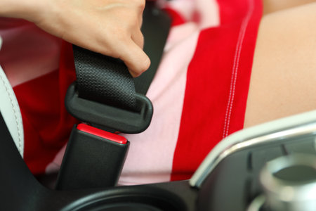 Female driver fastening safety belt in car, closeupの写真素材