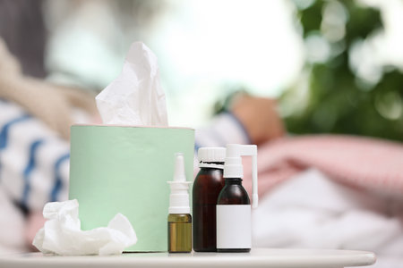 Cough remedies and box with tissues on tableの写真素材