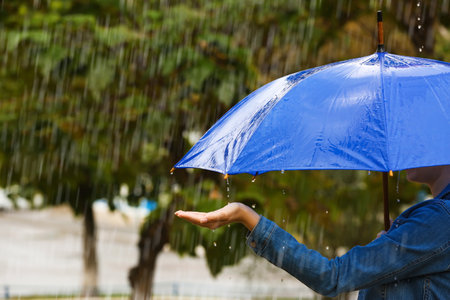 Woman with bright umbrella under rain on street, closeupの写真素材