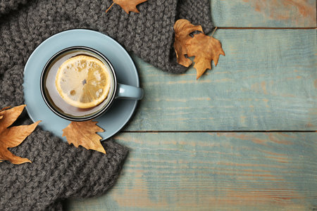 Flat lay composition with hot cozy drink and autumn leaves on wooden background. Space for textの写真素材