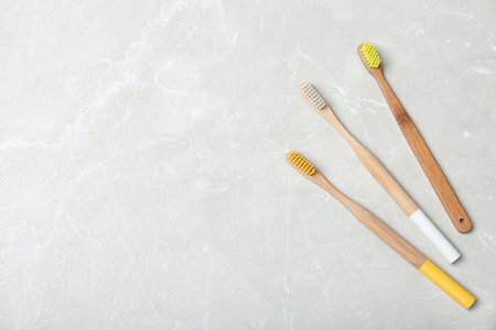 Bamboo toothbrushes and space for text on light background, top view. dental careの写真素材