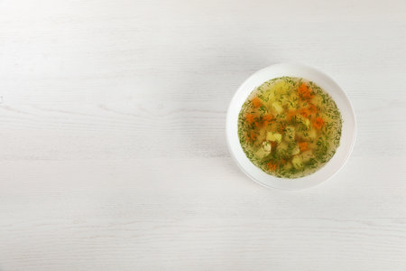 Bowl of fresh homemade soup to cure flu on wooden background, top view with space for textの写真素材