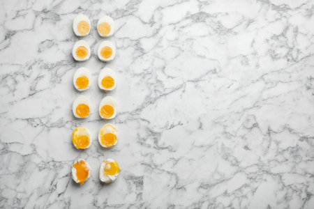 Various types of boiled eggs on marble background, flat lay with space for text. cooking timeの写真素材