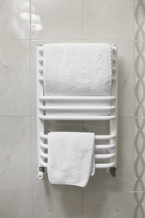Dryer with clean white towels on wallの写真素材
