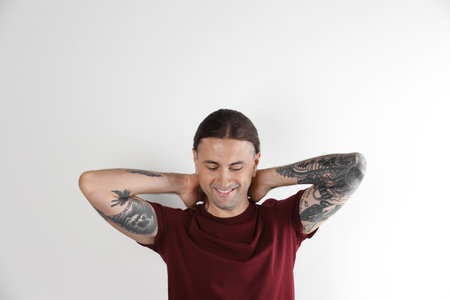 Young man with stylish tattoos on white backgroundの写真素材