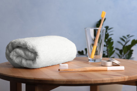 Set with bamboo toothbrushes and towel on tableの写真素材