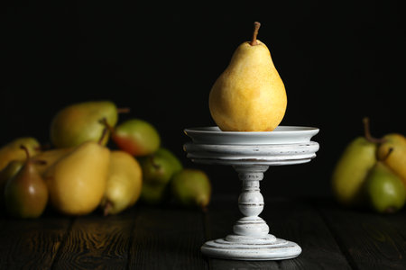 Stand with fresh ripe pear on table against blurred backgroundの写真素材