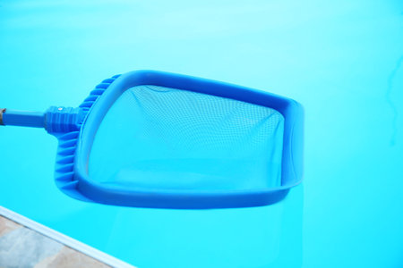 Cleaning outdoor pool with scoop net, closeup