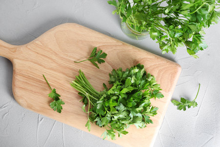 Flat lay composition with fresh green parsley on gray background