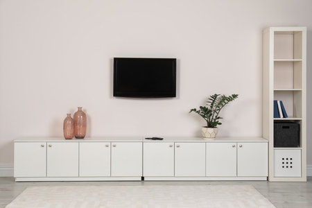 Modern TV set mounted on wall in living roomの写真素材