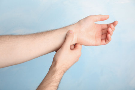 Man checking pulse on color background, closeup