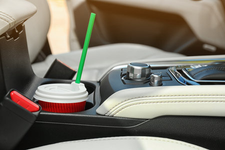 Takeaway paper coffee cup in holder inside carの写真素材