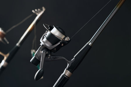 Modern spinning rod against dark background, closeup. fishing equipment