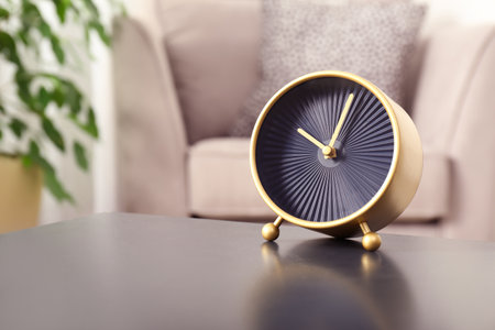 Stylish analog clock on table in living room, space for text. Time of dayの写真素材