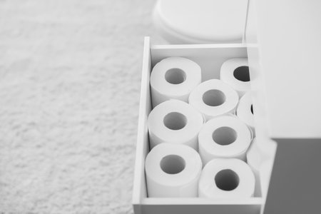 Open cabinet drawer with toilet paper rolls in bathroom. Space for textの写真素材
