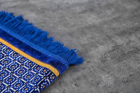 Muslim prayer rug and space for text on gray background