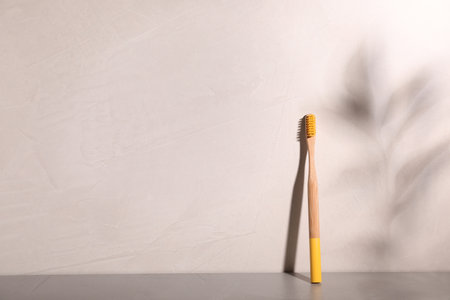 Bamboo toothbrush on table against gray background. Space for textの写真素材