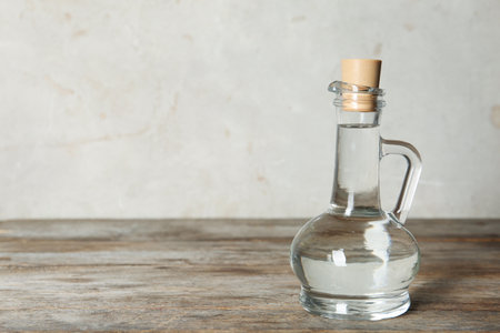 Glass jug with vinegar on table. Space for textの写真素材