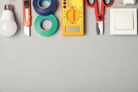 Flat lay composition with electrician's tools and space for text on gray background