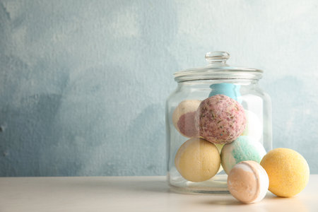 Jar with colorful bath bombs on table. Space for textの写真素材