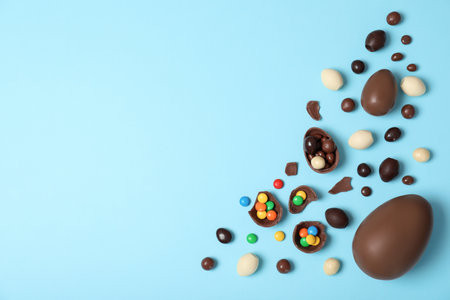 Flat lay composition with chocolate Easter eggs and space for text on color background