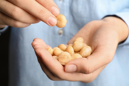 Woman holding shelled organic Macadamia nuts, closeupの写真素材