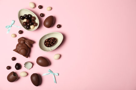 Flat lay composition with chocolate Easter eggs and space for text on color background