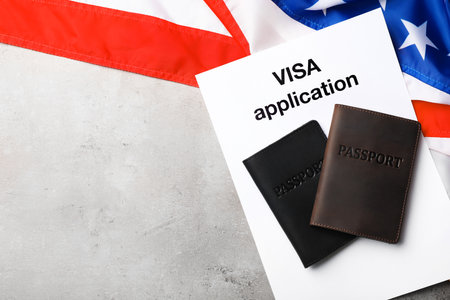 Flat lay composition with flag of USA, passports and visa application on gray background. Space for textの写真素材