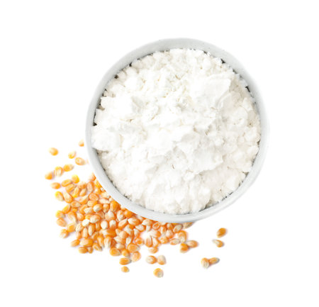 Bowl with corn starch and kernels on white background, top view