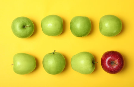 Red apple among green ones on color background, top view. be differentの写真素材