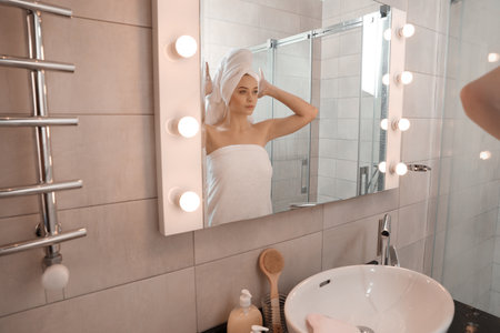 Young woman wrapped in towels near bathroom mirror. Using soapの写真素材