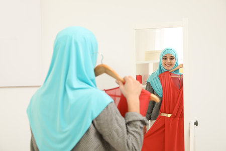 Muslim woman choosing clothes in modern shopの写真素材