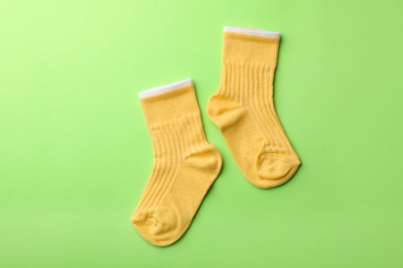 Cute child socks on color background, top view