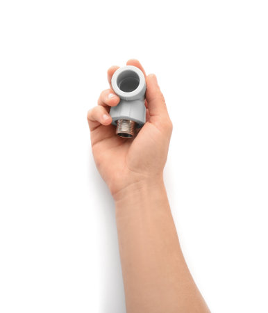 Plumber holding pipe fitting on white background, closeupの写真素材