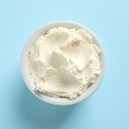 Bowl of tasty cream cheese on color background, top viewの写真素材