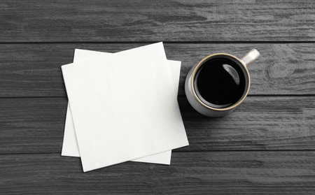 Cup of coffee and clean paper napkins on wooden background, top viewの写真素材
